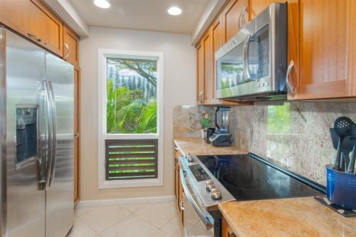 a kitchen with a stainless steel refrigerator and a window at 1722 Ridge in Kahana