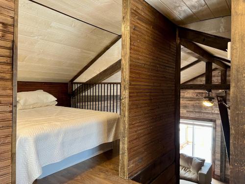 1 dormitorio con 1 cama y pared de madera en Chalet Romanov en Saint-René-de-Matane