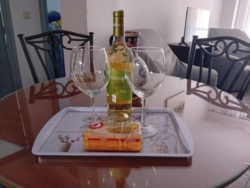 uma garrafa de vinho e dois copos numa mesa em Alojamiento Auri em Almuñécar