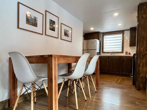 cocina con mesa de madera y sillas blancas en Chalet Romanov en Saint-René-de-Matane