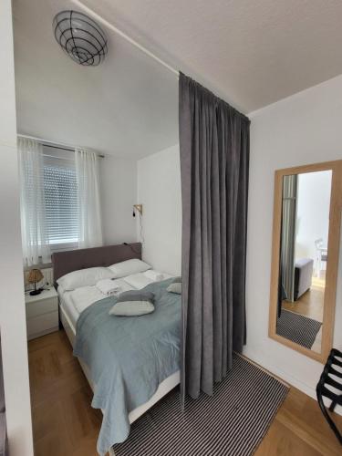 - une chambre avec un lit, une fenêtre et un miroir dans l'établissement Studio Apartman Ana, à Zagreb
