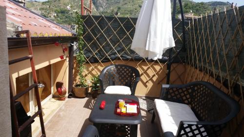 a balcony with a table and chairs and an umbrella at Romantico monolocale veranda privata vista mare in Reggio Calabria