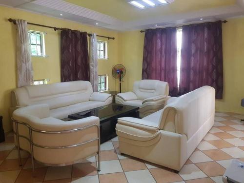 a living room with white couches and chairs at Adorable 2bedroom homestay in Beau Bassin
