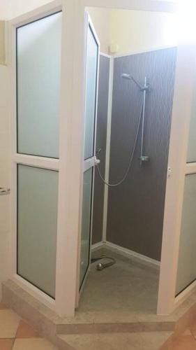 a bathroom with a shower with a glass door at Adorable 2bedroom homestay in Beau Bassin