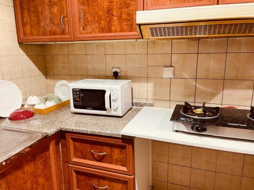 y cocina con microondas y fogones. en Happy Hostel, en Dubái