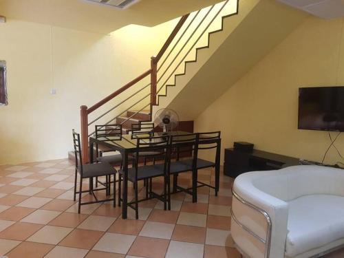 a dining room with a table with chairs and a staircase at Adorable 2bedroom homestay in Beau Bassin
