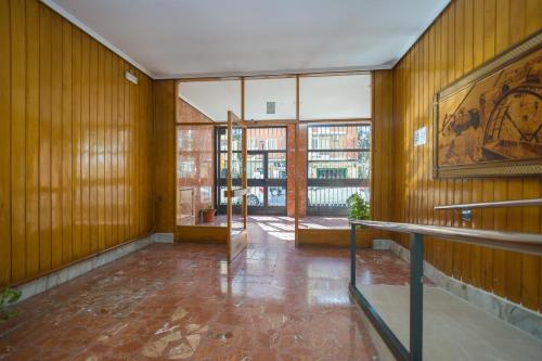 Habitación vacía con paredes de madera y ventana grande. en PISO VANDELVIRA, en Albacete