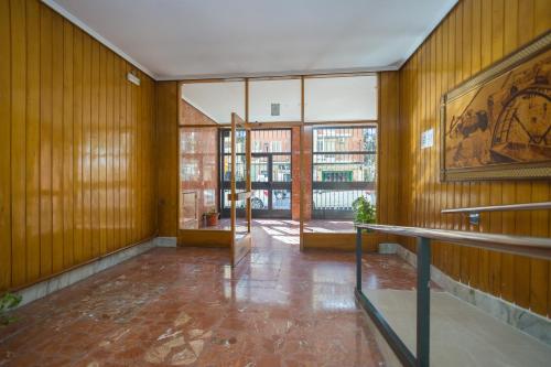 an empty room with wooden walls and a large window at PISO VANDELVIRA in Albacete