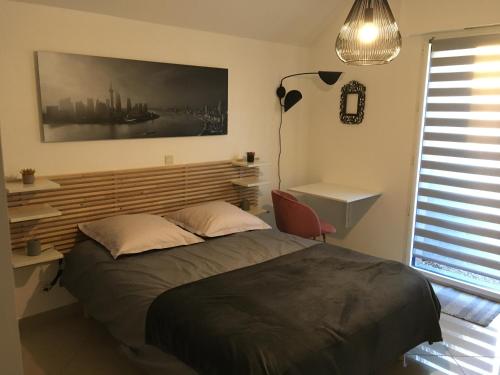 a bedroom with a bed and a desk and a lamp at Chambre confortable avec une entrée indépendante - Parking & accès Lille facile in Marcq-en-Baroeul