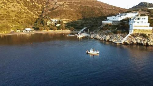 un bateau dans une masse d'eau à côté d'une montagne dans l'établissement Pandaisia Φούρνοι Κορσεων, à Fourni