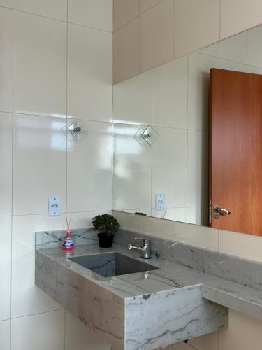 ein Badezimmer mit Waschbecken und großem Spiegel in der Unterkunft Castelo fort in Caparaó Velho