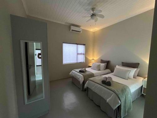 Habitación de hotel con 2 camas y ventana en Comfortable home centrally located in Hoedspruit, en Hoedspruit