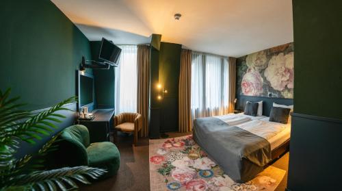 um quarto de hotel com uma cama e um sofá em Stadshotel Heerlen em Heerlen