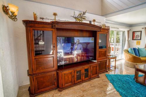 a large wooden entertainment center with a television in a living room at NEW Chalk Sound Home BBQ Pool Beach Steps Away in Providenciales