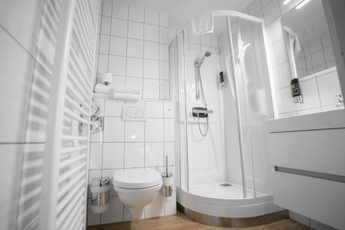 y baño blanco con ducha y aseo. en Stadshotel Heerlen, en Heerlen