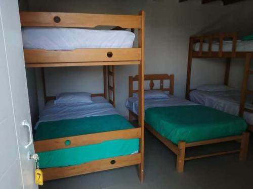 two bunk beds in a small room with a green mattress at HOTEL PARAACO in Paracas