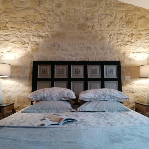 une chambre avec un grand lit avec deux oreillers dans l'établissement Le Clos des Treilles, à Nuaillé-dʼAunis