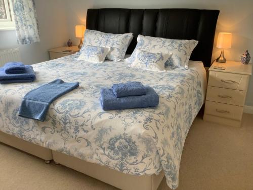 a bedroom with a bed with blue towels on it at Private room in bright detached house in Salisbury