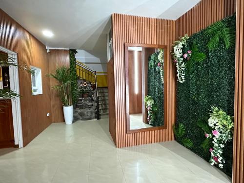 a hallway with a green wall with flowers and plants at Hotel Villamar in Quito