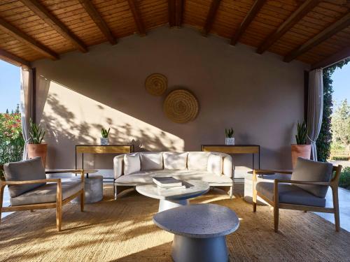 a living room with a couch and chairs and tables at Baia Di Chia Resort Sardinia, Curio Collection By Hilton in Chia