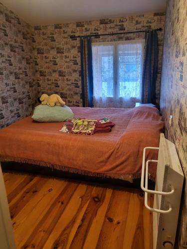 une chambre avec un lit avec un animal en peluche dessus dans l'établissement Charmante maison de village, à Antugnac