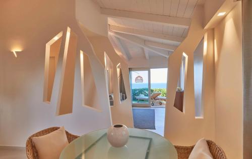 a dining room with a glass table and chairs at Baia Di Chia Resort Sardinia, Curio Collection By Hilton in Chia