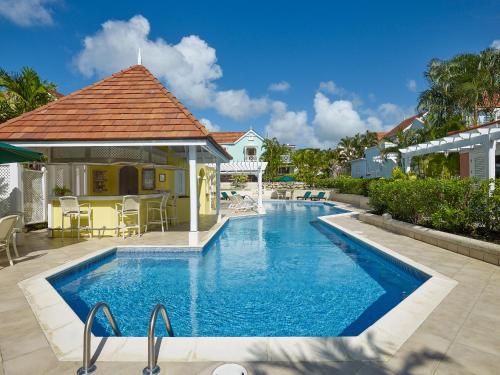 a swimming pool in front of a house at Kings Beach Village in Saint Peter