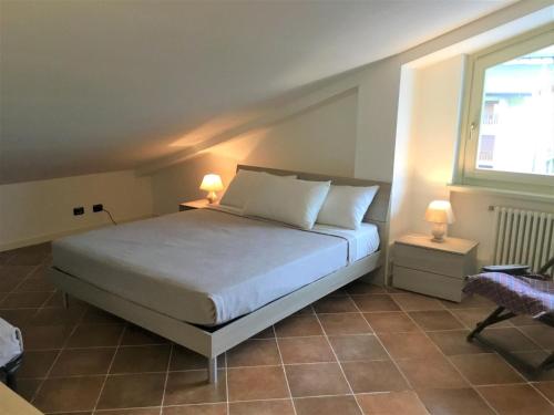 una camera con un letto e una finestra e due lampade di Appartamento Ottoz Aosta ad Aosta