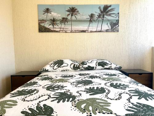 a bedroom with a bed and a picture of palm trees at Foro Sol in Mexico City