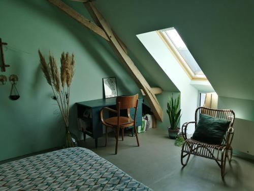 Schlafzimmer mit einem Bett, einem Schreibtisch und Stühlen in der Unterkunft Les chambres de balade au jardin in Épineu-le-Chevreuil