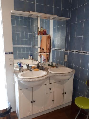 La salle de bains est pourvue de deux lavabos et de carreaux bleus. dans l'établissement Maison T7, à Brest