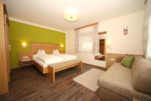 een slaapkamer met een bed en een bank bij Appartement Kristall in Schladming