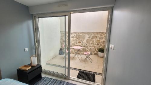 a room with a sliding glass door leading to a patio at Appartement 2 CHAMBRES meuble a saix 48 m2 avec COUR in Saix