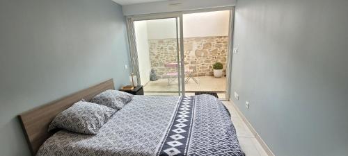 a bedroom with a bed and a glass door at Appartement 2 CHAMBRES meuble a saix 48 m2 avec COUR in Saix