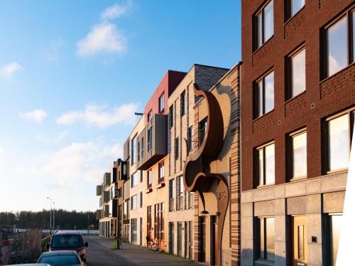 a row of brick buildings on a street at Huis met de krul in Amsterdam