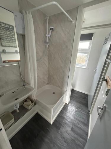 a white bathroom with a shower and a sink at 1st Floor family apartment Hillview in Brean