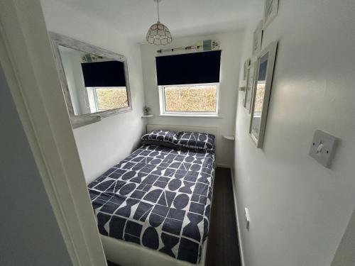 a small bedroom with a bed and two windows at 1st Floor family apartment Hillview in Brean