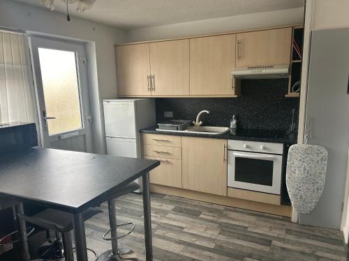 a kitchen with wooden cabinets and a table and a sink at 1st Floor family apartment Hillview in Brean