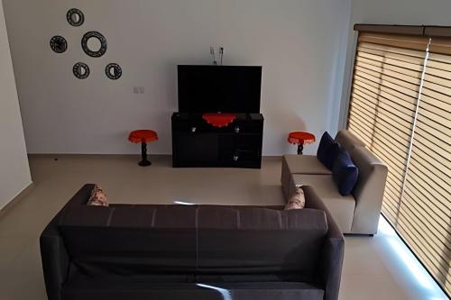 a living room with a couch and a tv at Portezza Natura in Mazatlán