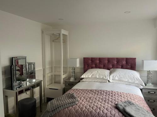 a bedroom with a large bed with a purple headboard at Johnsville House in Carlow