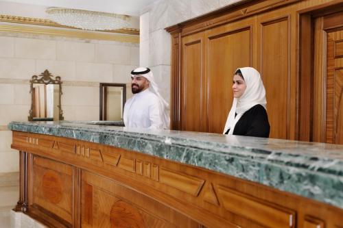 a man and a woman standing behind a counter at InterContinental Dar Al Hijra Madinah by IHG in Al Madinah