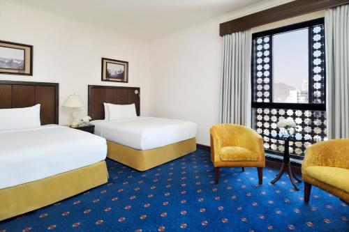 a hotel room with two beds and a window at InterContinental Dar Al Hijra Madinah by IHG in Al Madinah