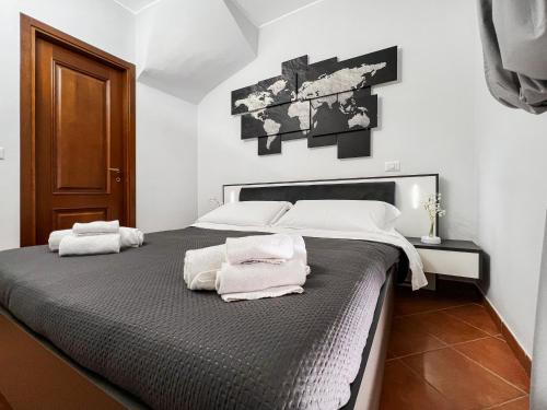 a bedroom with a large bed with towels on it at Coastal Serenity - 300mt from the Sea - Netflix in Fiumicino