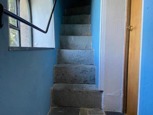 a staircase in a house with a blue wall at Brynkir Tower in Llanfihangel-y-pennant