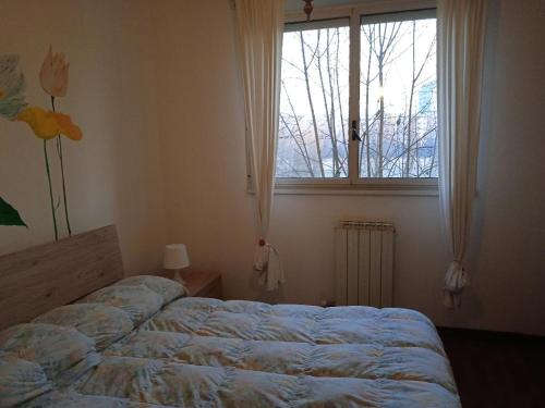een slaapkamer met een bed voor een raam bij La Casa di Boh, vicino ospedale San Paolo, Iulm, Forum Assago in Milaan