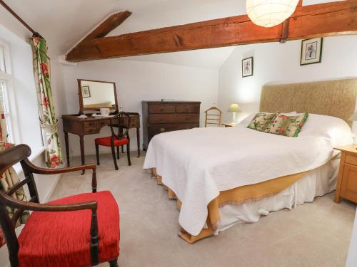 a bedroom with a bed and a desk and a chair at The Cottage in Holywell