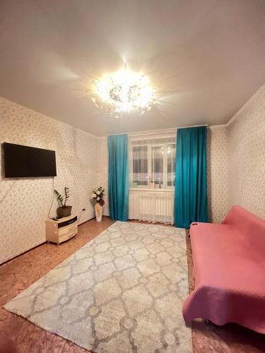 sala de estar amplia con sofá y TV en Квартира en Kokshetau