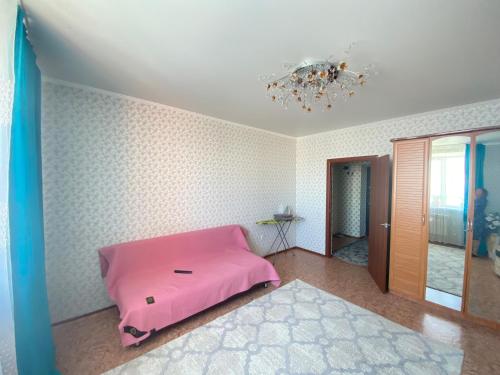 a bedroom with a pink bed in a room at Квартира in Kokshetau