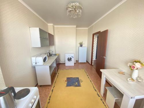 a small kitchen with a sink and a microwave at Квартира in Kokshetau