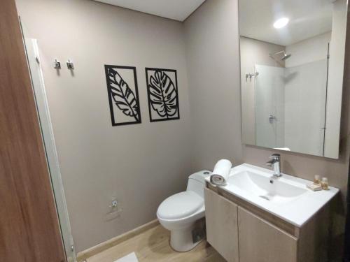 a bathroom with a toilet and a sink and a mirror at The Hood 102, Modern and Luxury Apartments in Bogotá